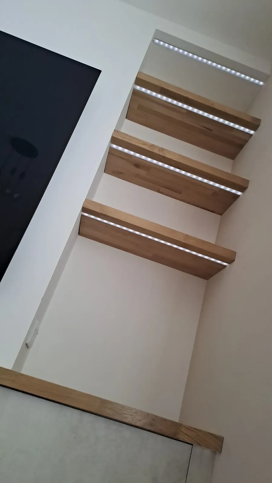 Warm lit shelving with integrated downlights, reactive ambient lighting