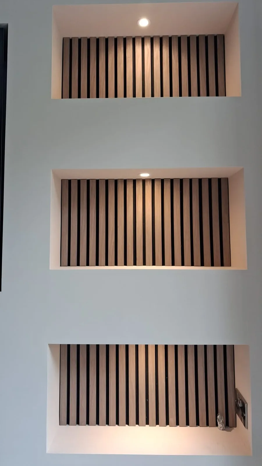Media wall with TV, soundbar and floating oak shelves with LED strip lighting