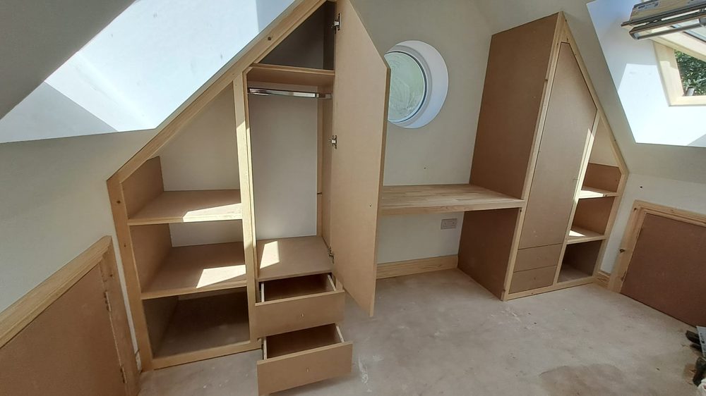 Full-width fitted bedroom storage with wardrobes, shelving and drawers